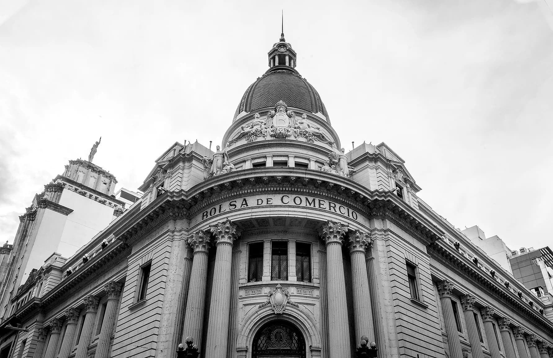 Fachada de la Bolsa de Comercio con su cúpula, vista desde abajo, en blanco y negro